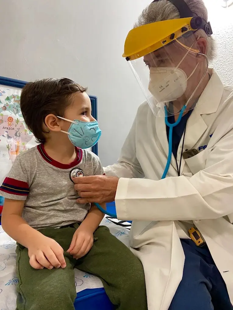 El Dr. Hashimoto revisa a un niño con el estetoscopio en el consultorio